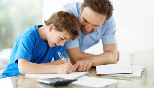  Padre ayudando a hacer los deberes a su hijo
