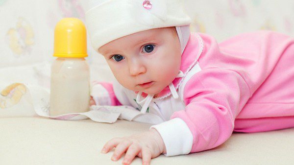 Bebé con biberón de leche antireflujo
