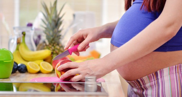 Embarazada cortando fruta