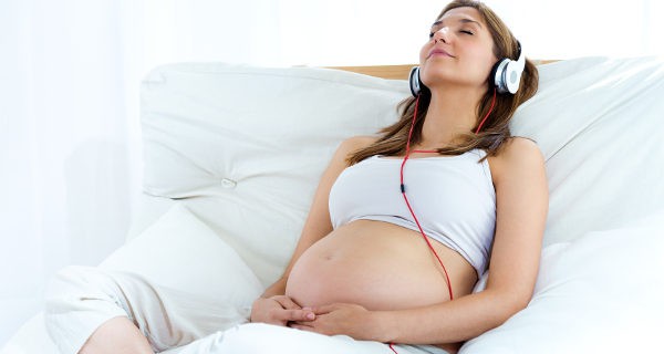 Embarazada escuchando música en el sofá