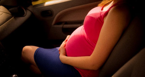 mujer embarazada viajando en coche