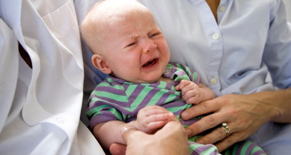 bebé llorando en brazos de los padres