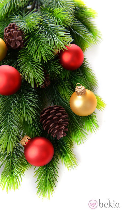 Árbol de Navidad decorado con bolas doradas y rojos y piñas